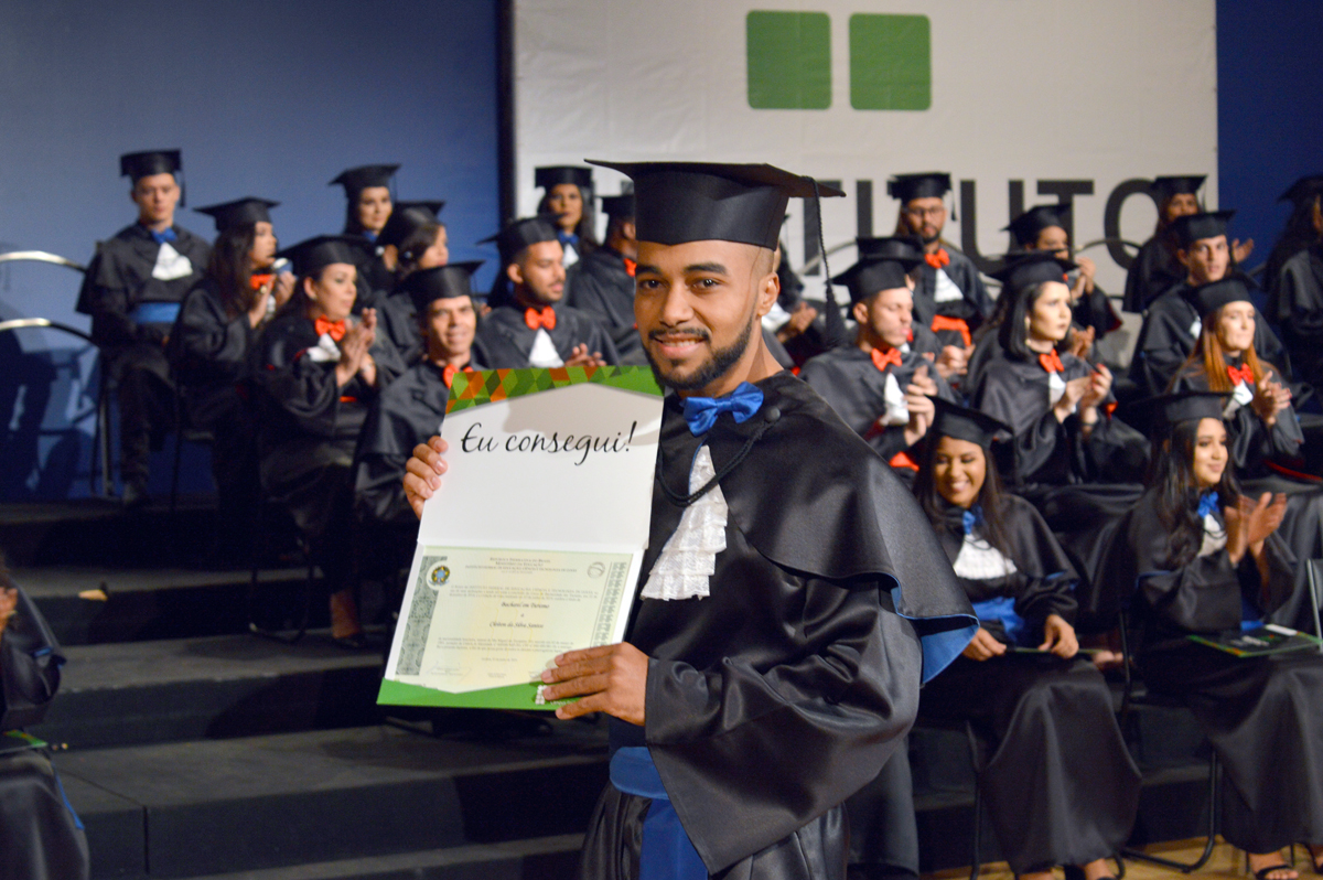 Formando exibe orgulhoso seu diploma de Bacharel em Turismo 